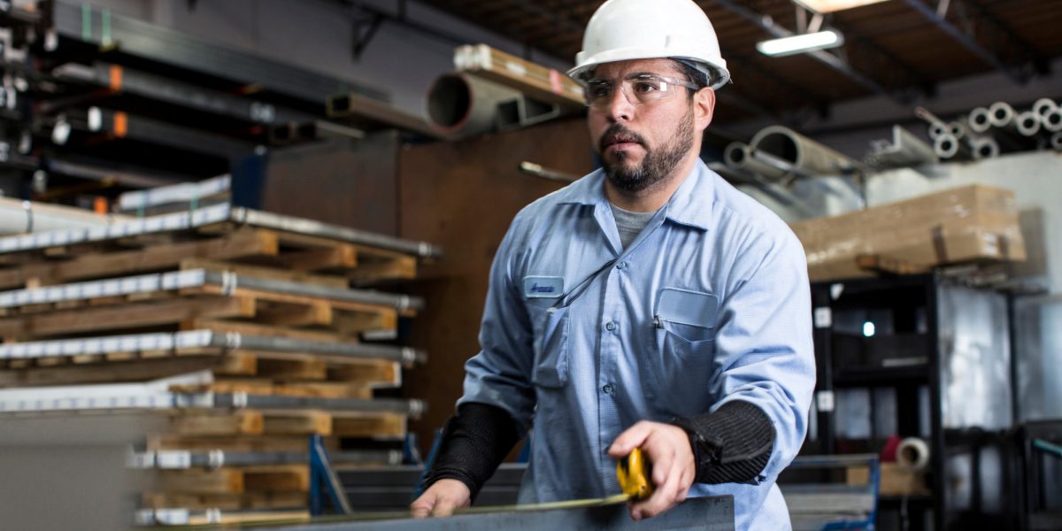 Worker measuring in metal plant