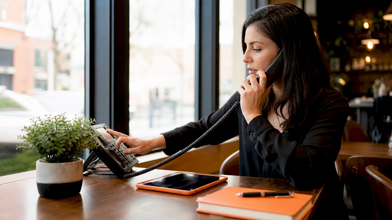 Woman setting up professional phone system in home office
